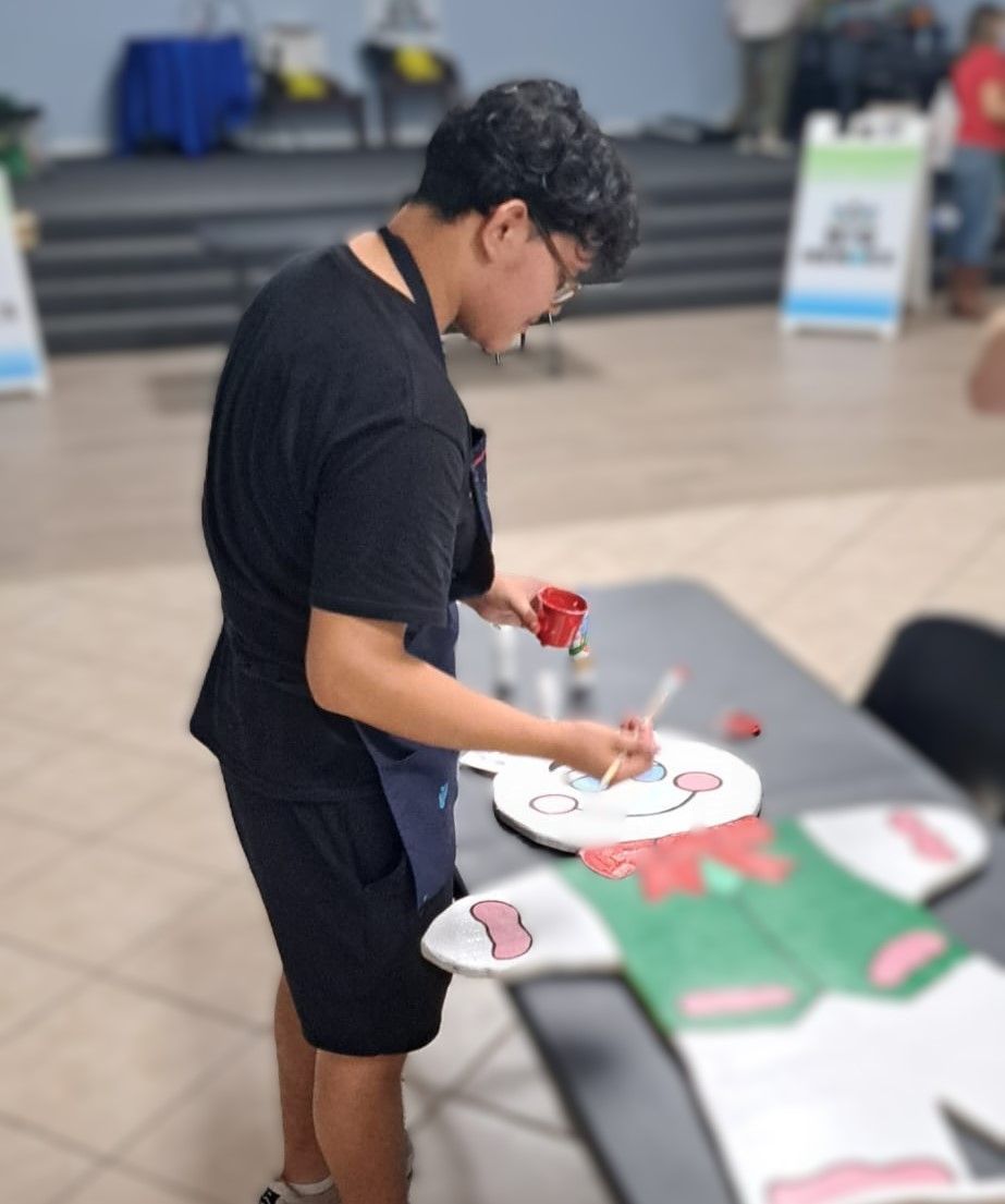 A man is painting a smiley face on a piece of paper
