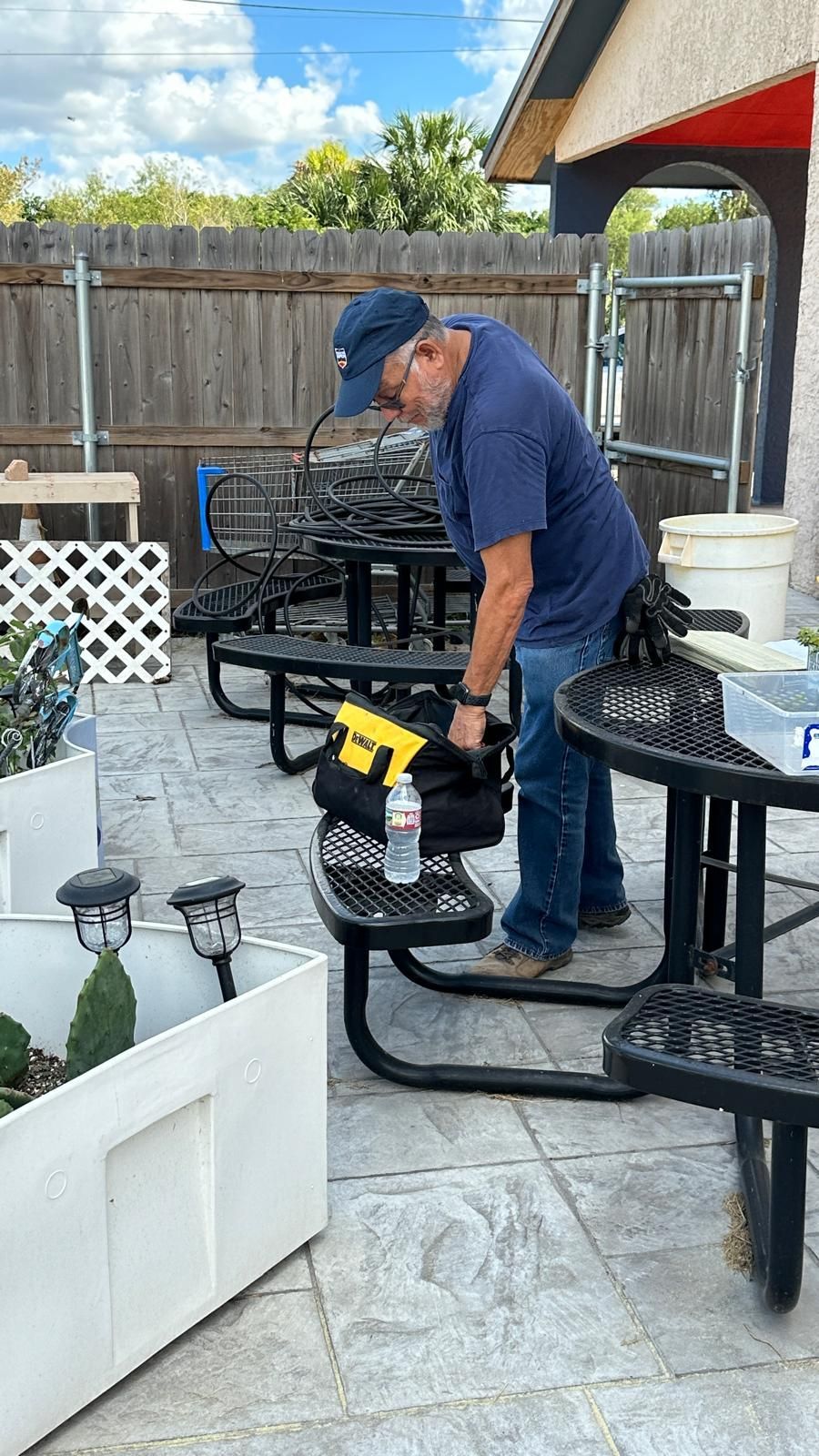A man is cleaning a picnic table outside of a restaurant.