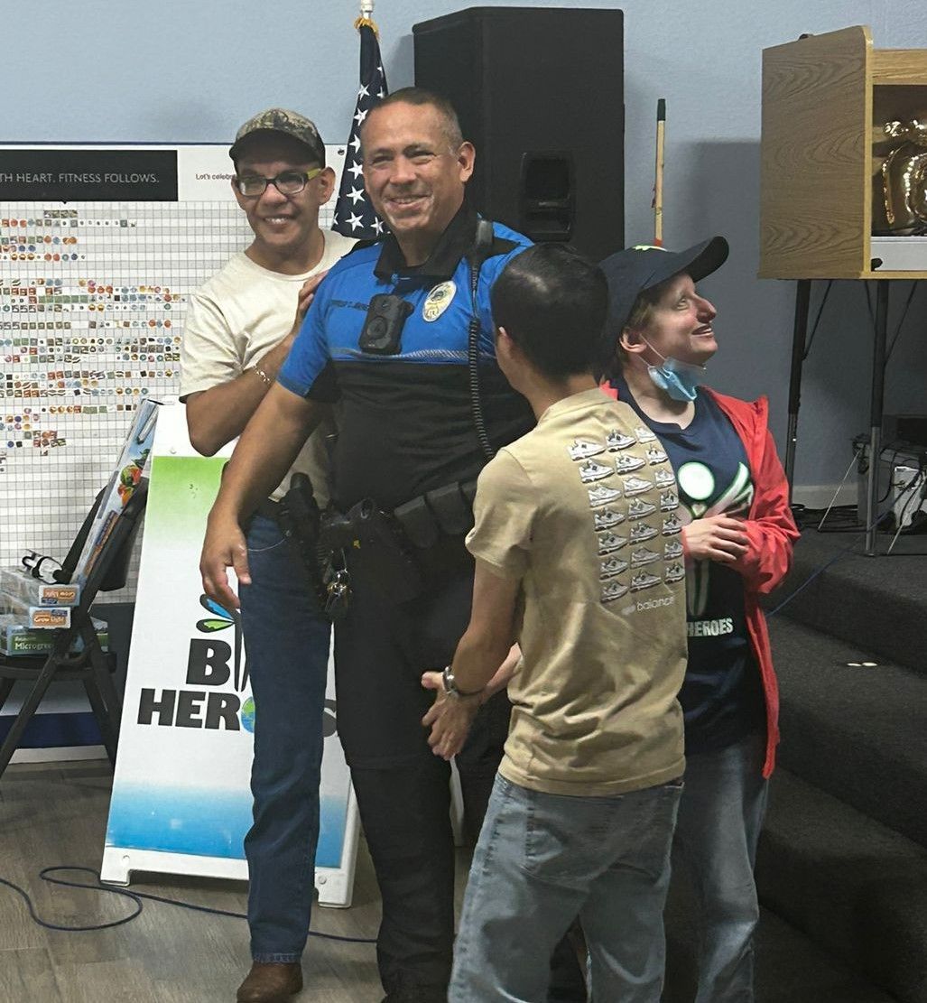 A group of people standing in front of a sign that says be her