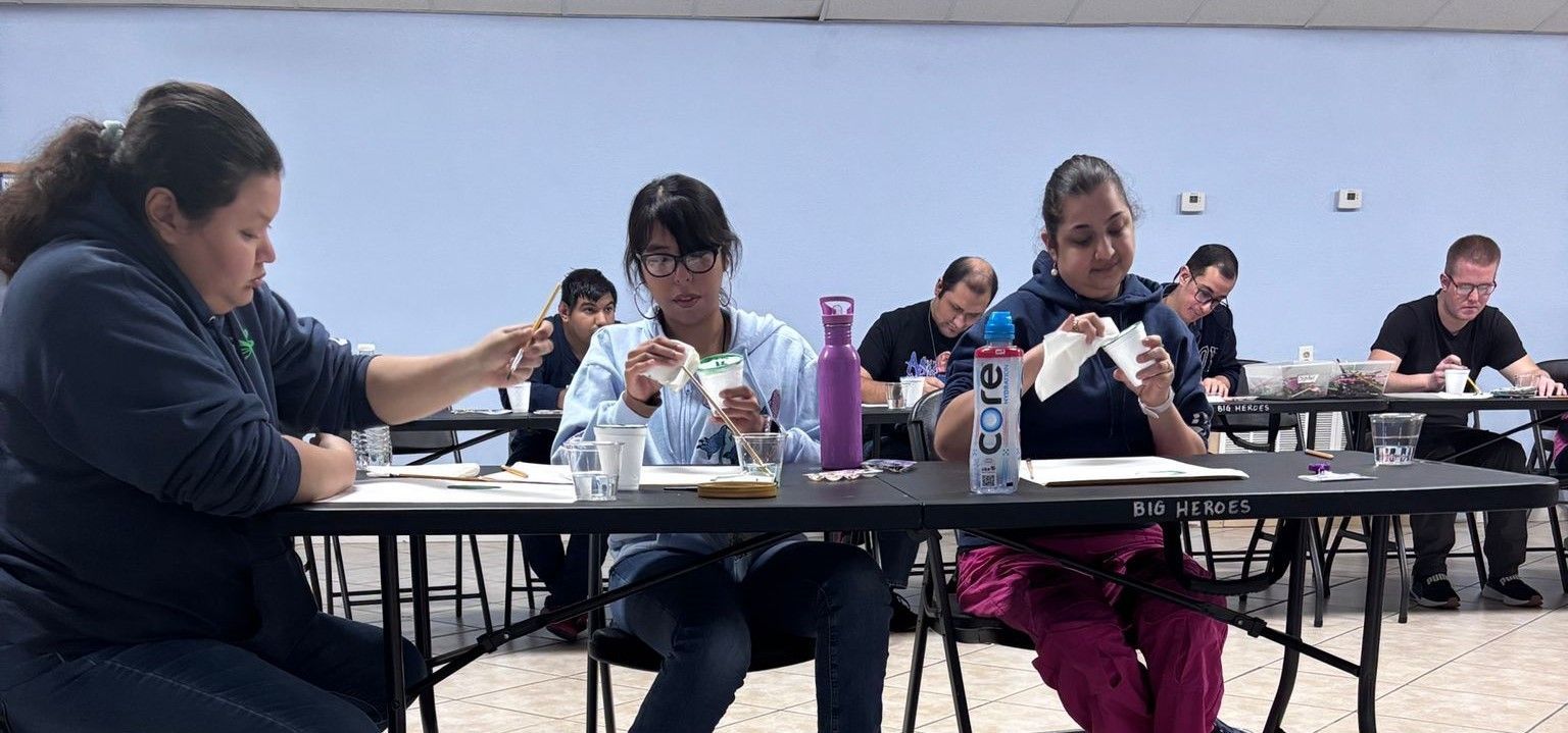 A group of people are sitting at tables in a room eating food.