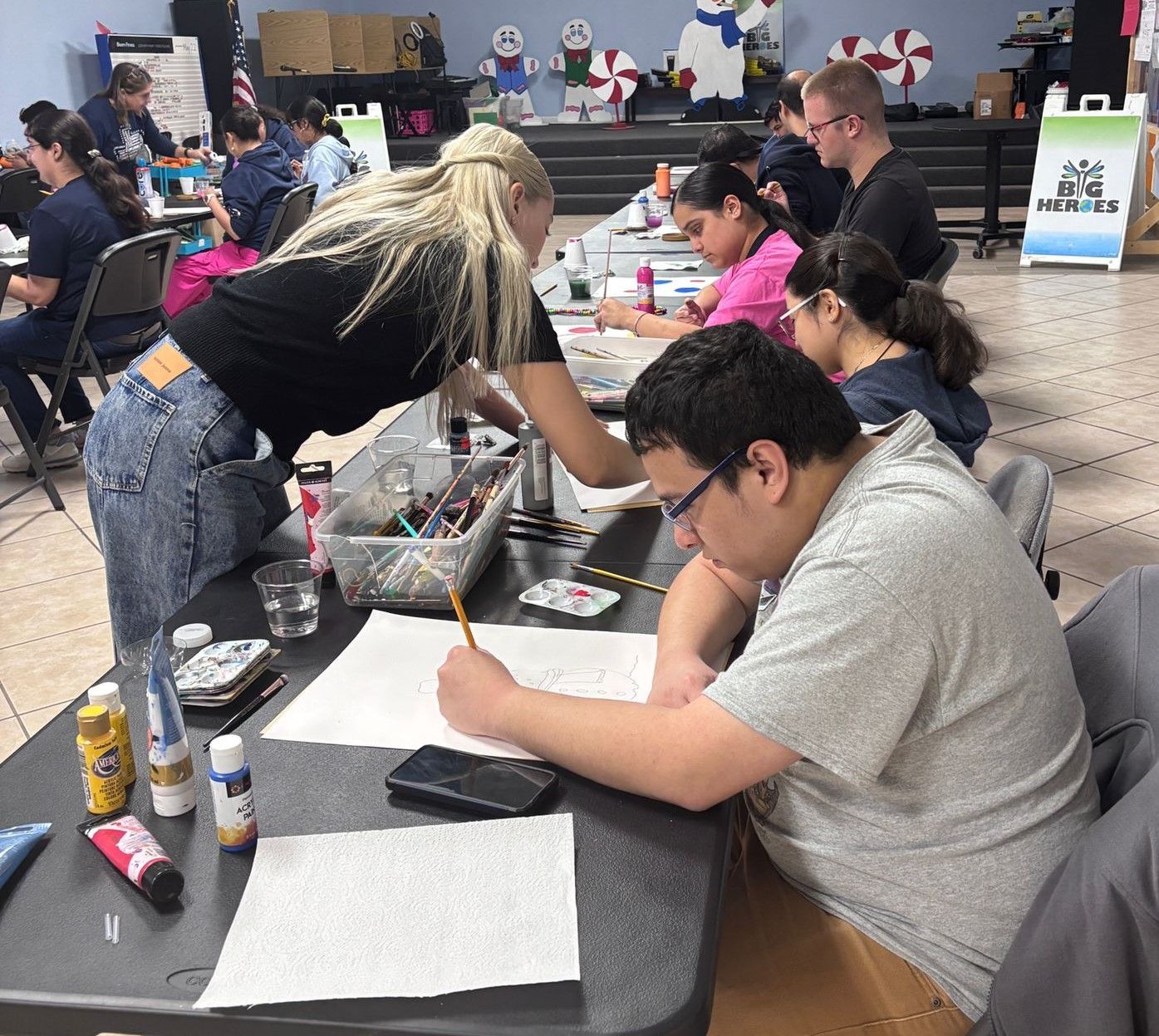A group of people are sitting at a table writing on paper