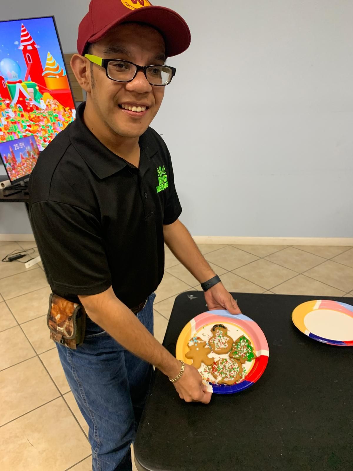A man is holding a plate with a gingerbread man on it