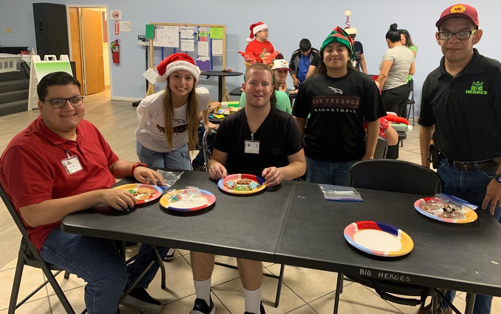 A group of people are sitting at a table with plates of food.