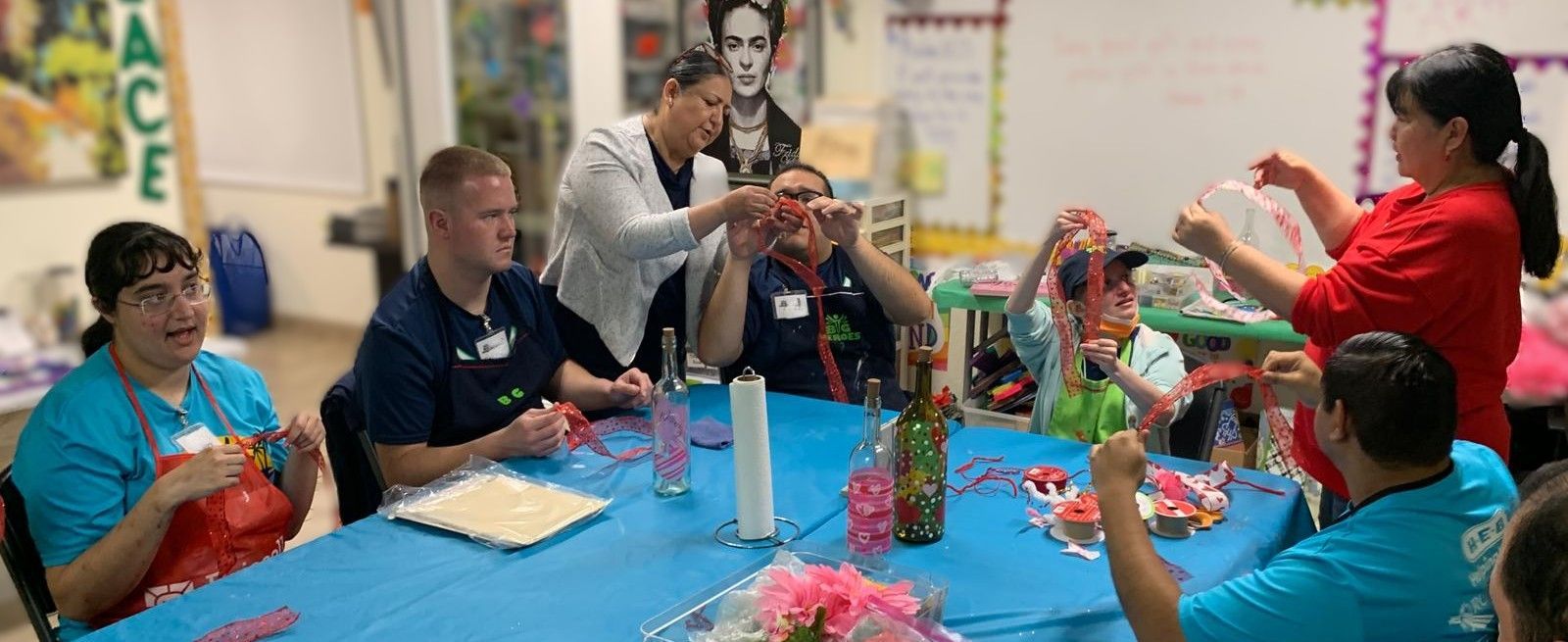 A group of people are sitting around a table making crafts.
