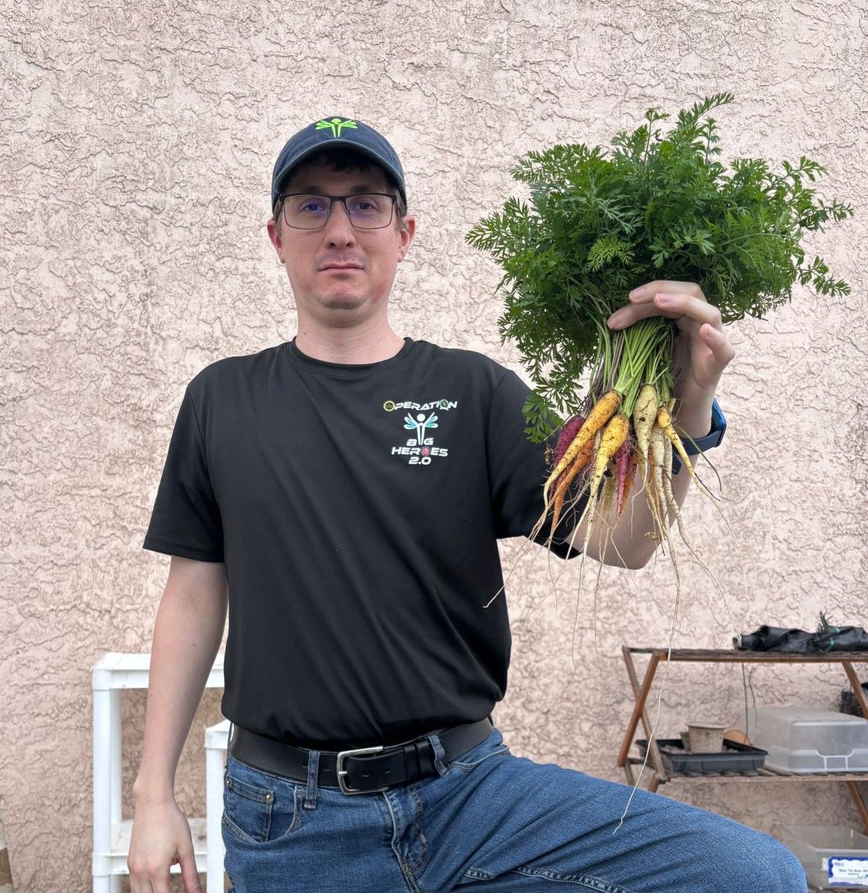 A man is holding a bunch of carrots in his hand