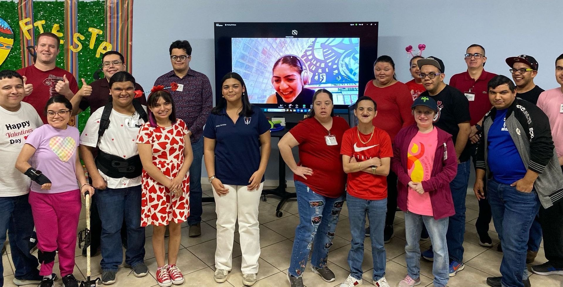 A group of people are posing for a picture in front of a television.