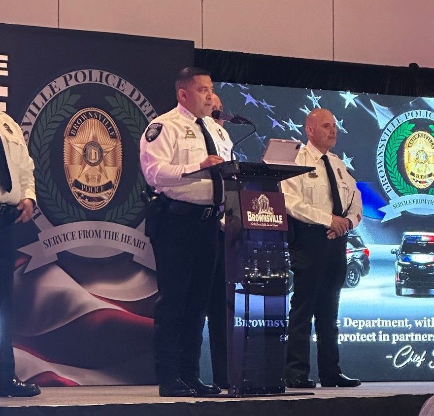 A group of police officers stand at a podium in front of a wall that says ' hills police department ' on it
