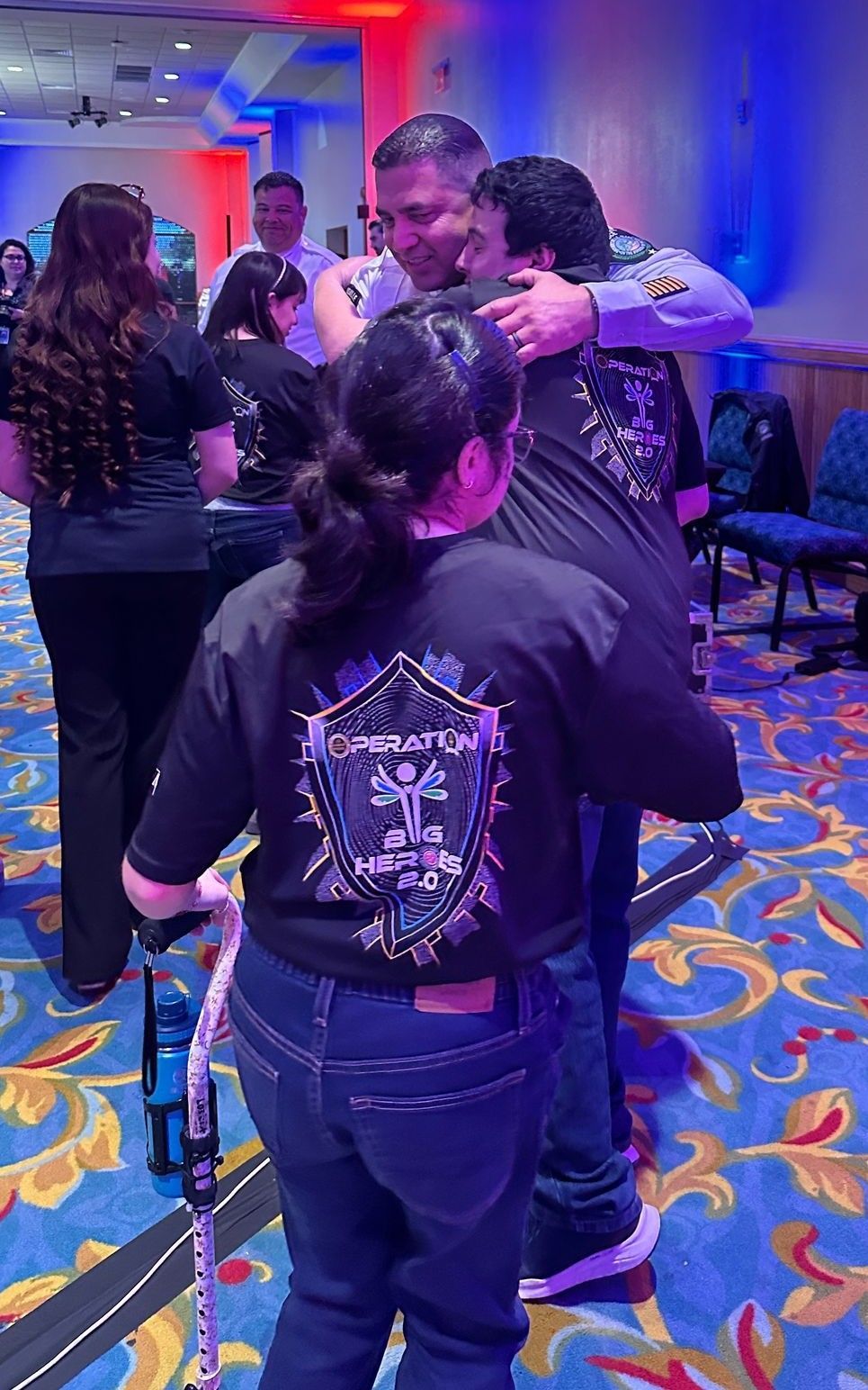 A group of people are hugging each other in a room.