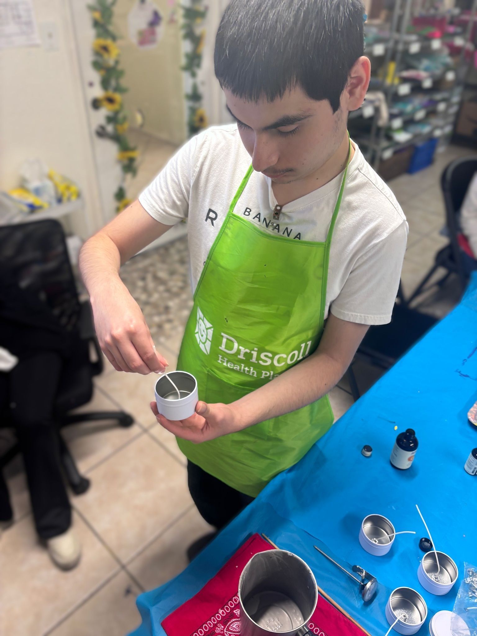 A boy wearing a green apron that says driscoll on it