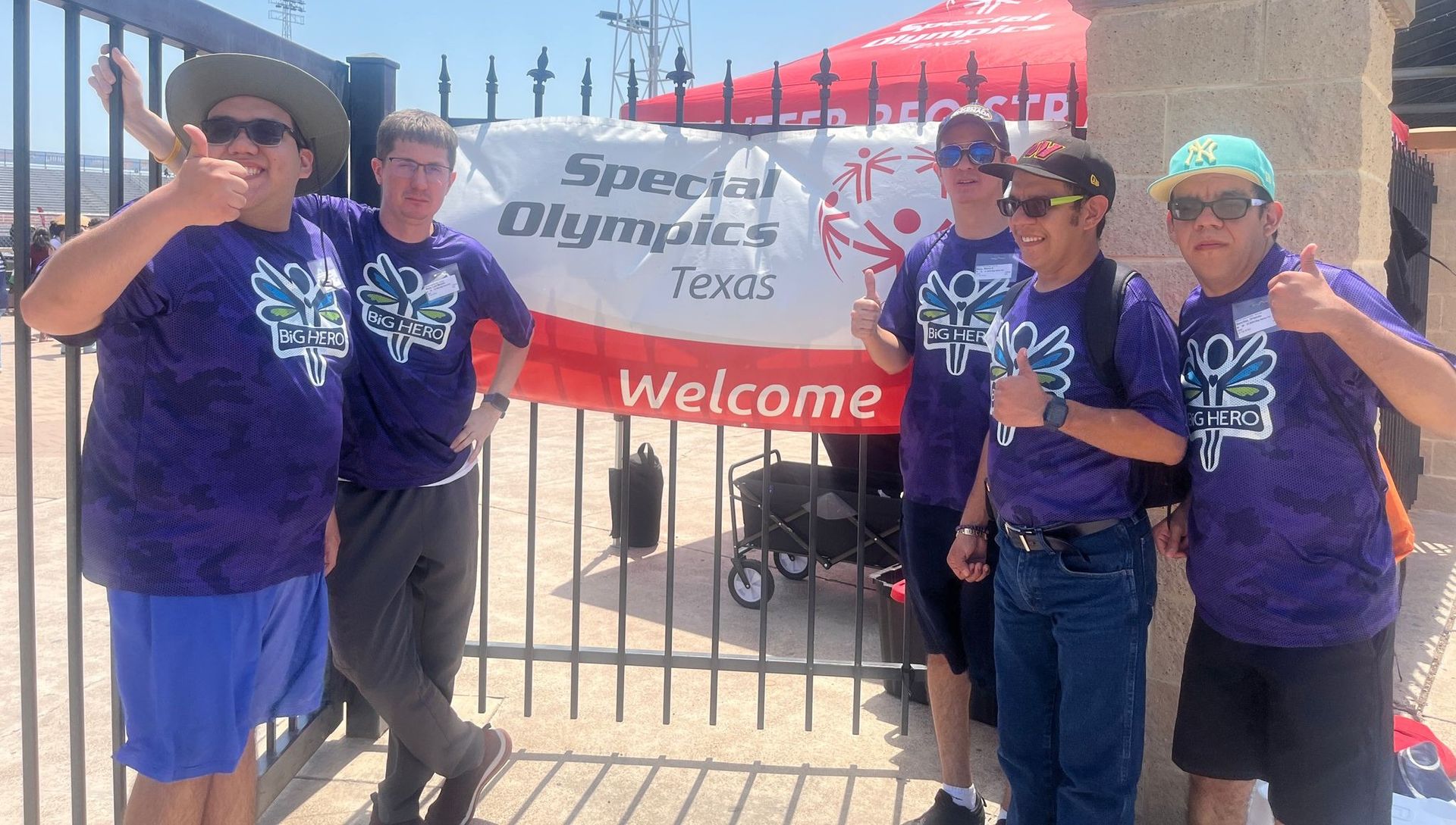 A group of people standing in front of a sign that says special olympics texas