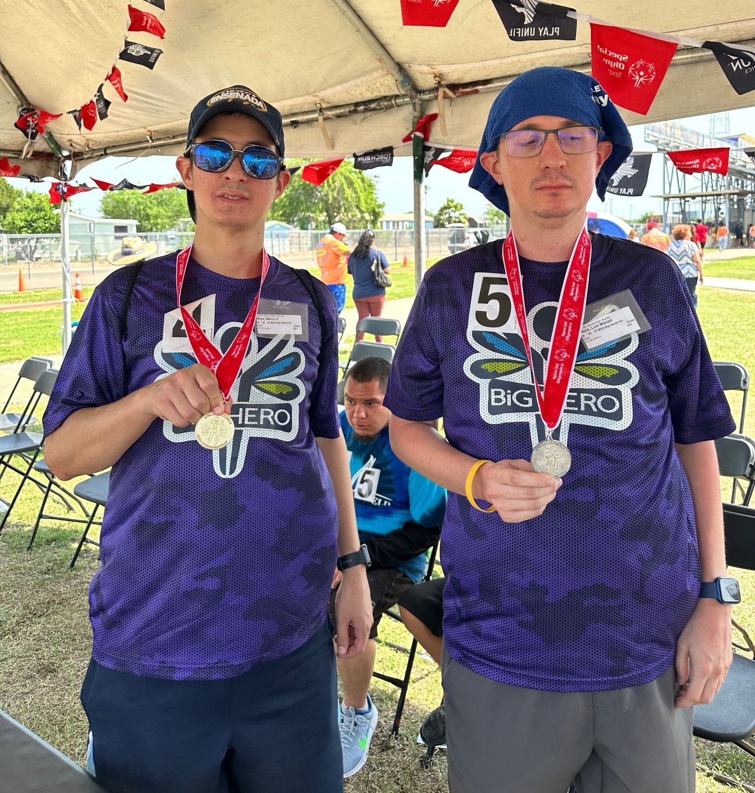 Two men wearing purple shirts with the number 5 on them