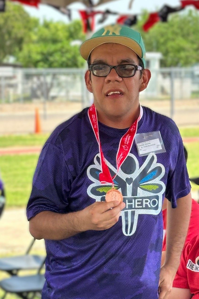 A man wearing a purple shirt with the word hero on it