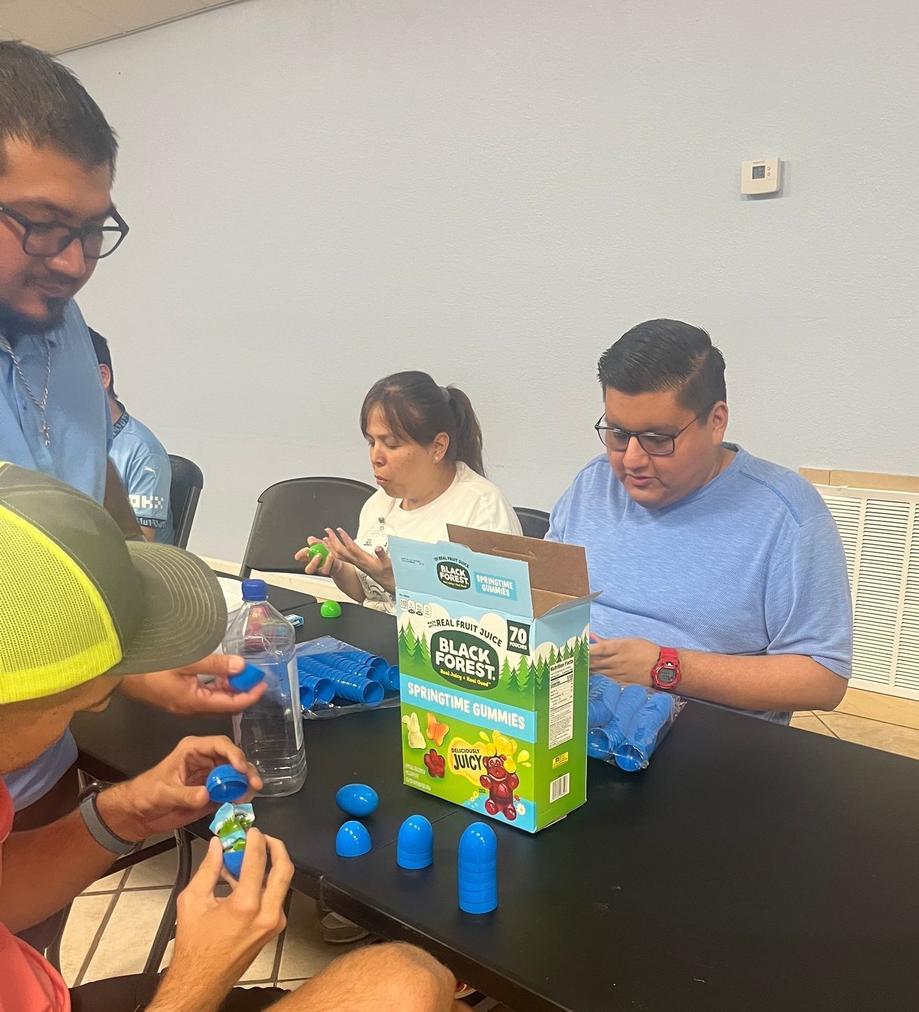 A group of people are sitting at a table with a box of rock n ' rollers on it