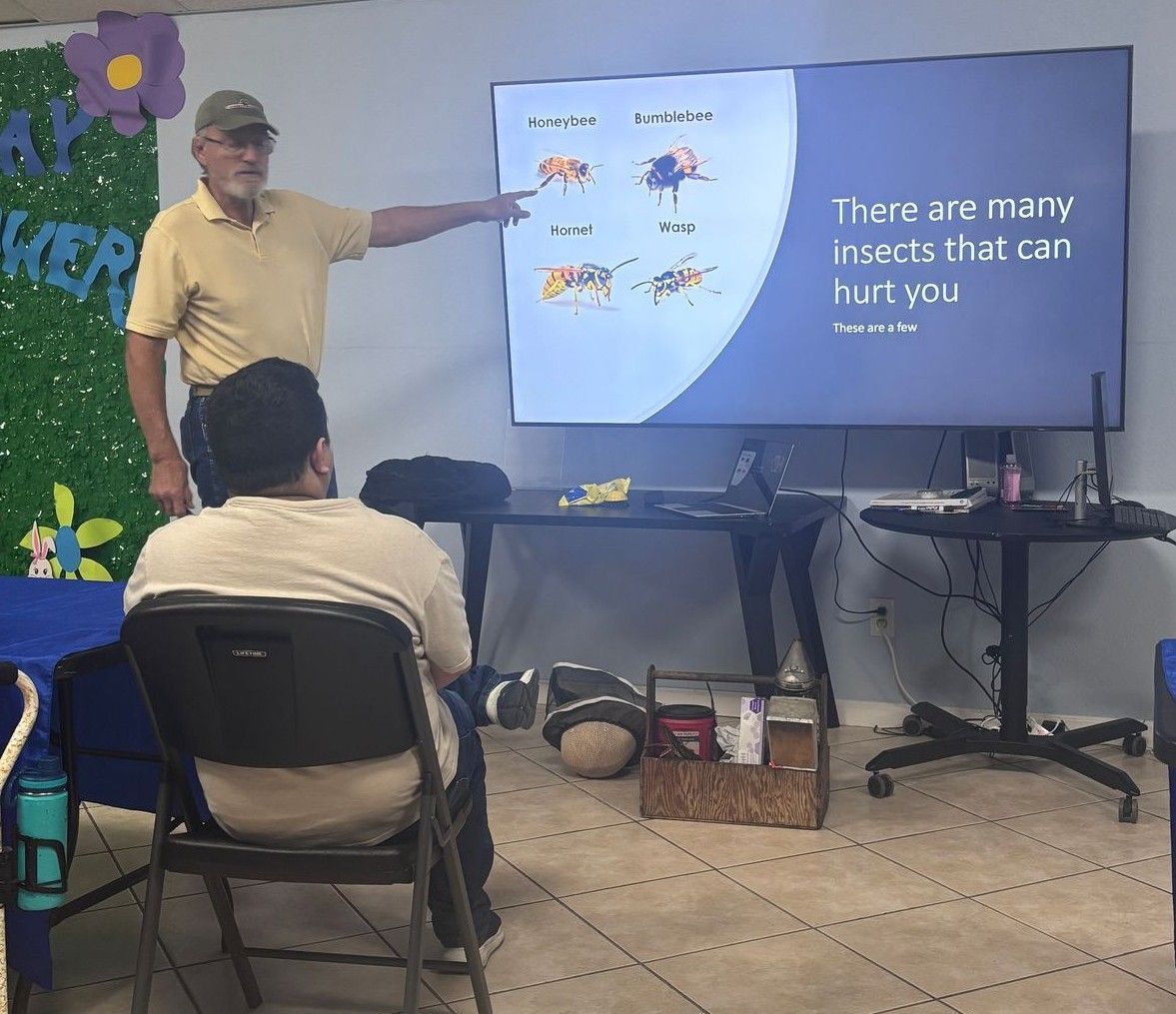 A man is pointing at a screen that says there are many insects that can hurt you