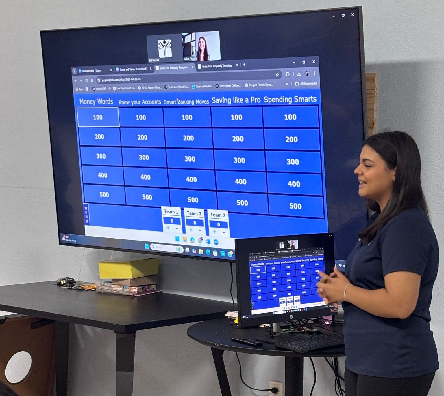 A woman is standing in front of a large screen that says jeopardy on it