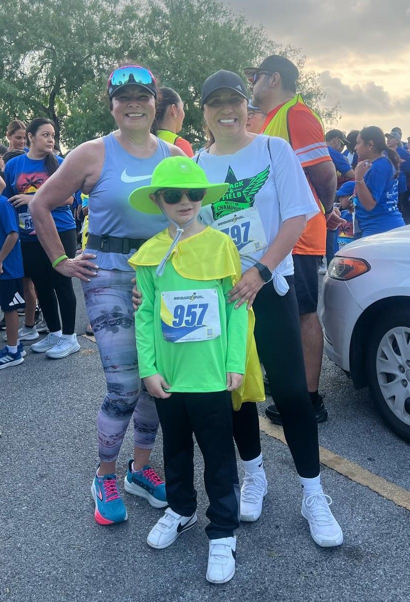 A group of people are standing next to each other in front of a car.