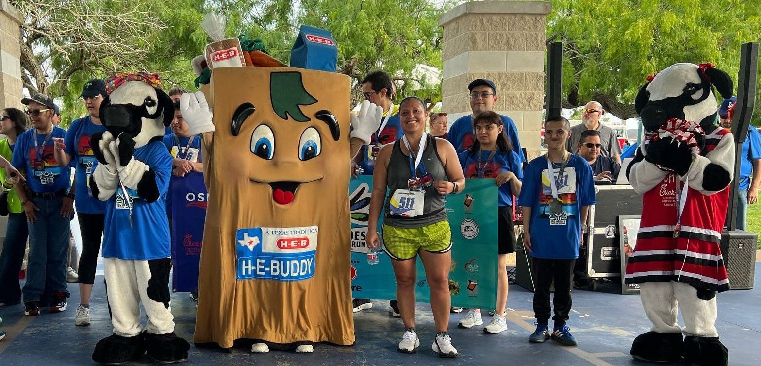A group of people are standing next to mascots at a race.