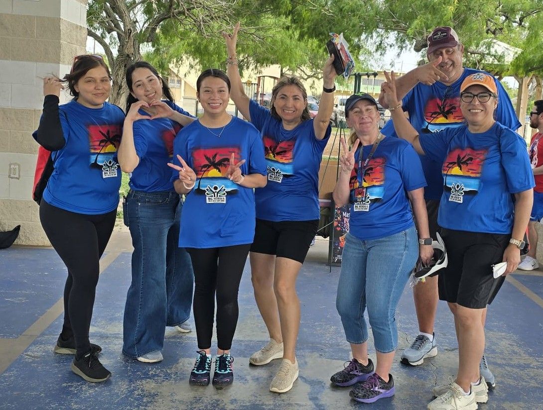 A group of people wearing blue shirts with palm trees on them