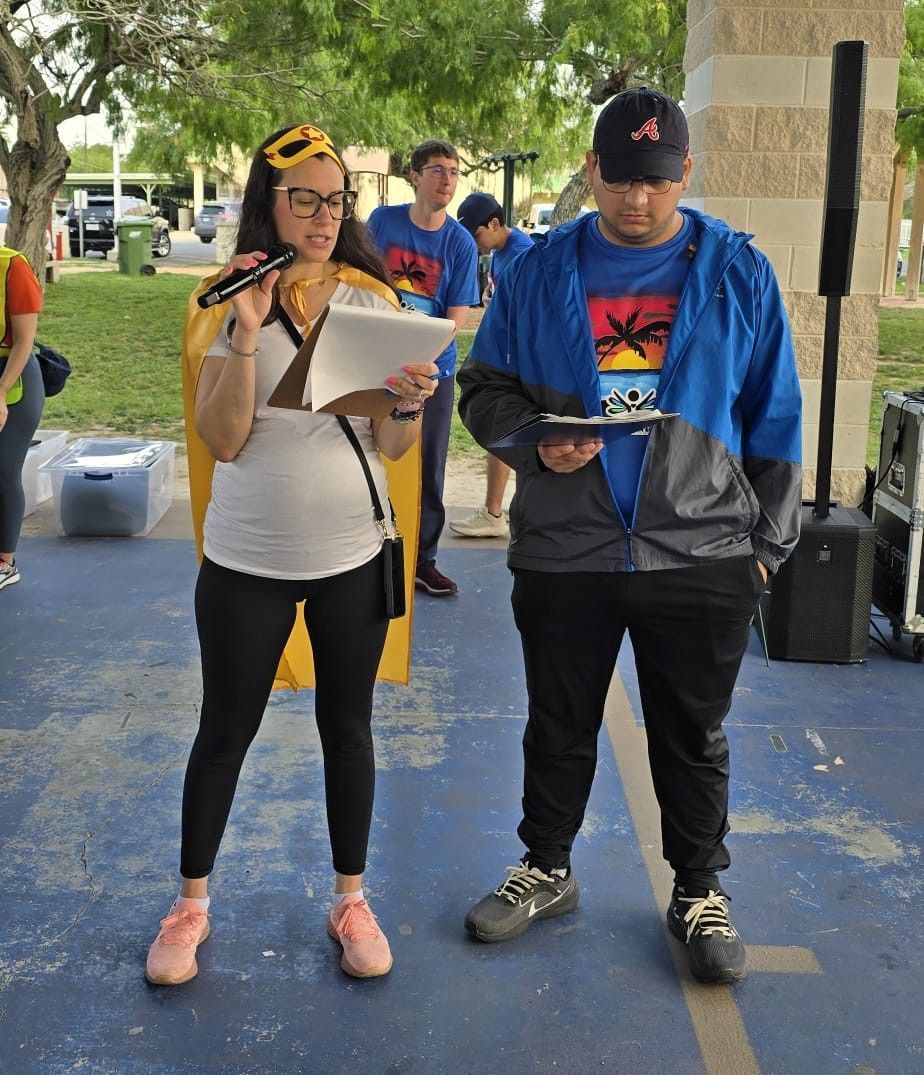 A man in a blue jacket is standing next to a woman in a yellow cape