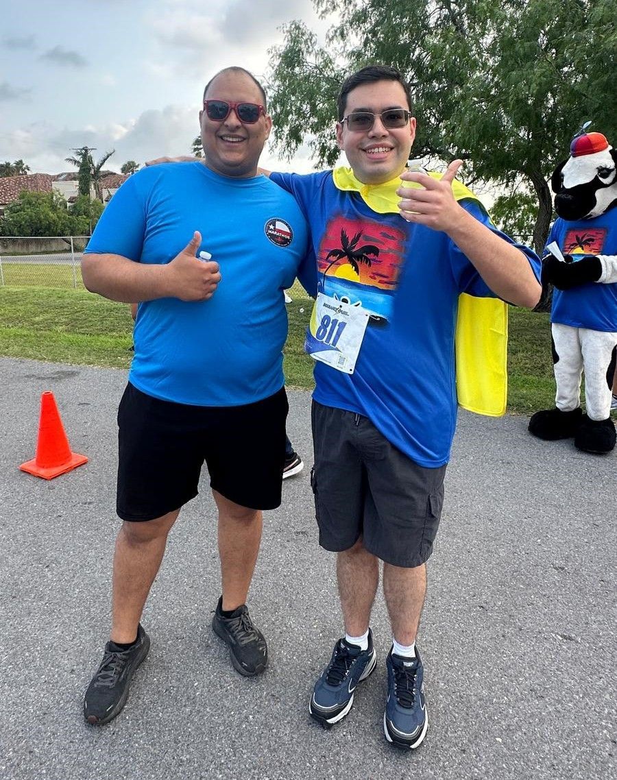 Two men are posing for a picture and one has the number 911 on his shirt