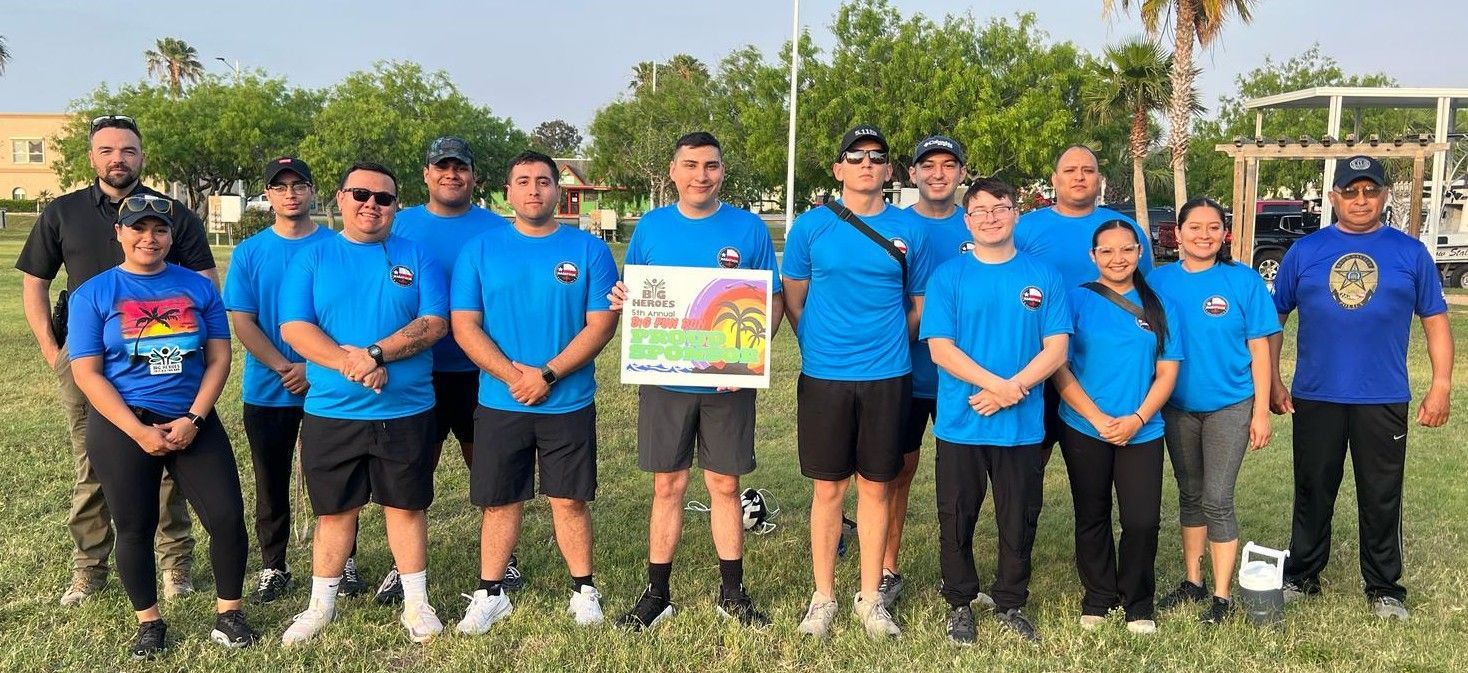 A group of people are posing for a picture in a field.