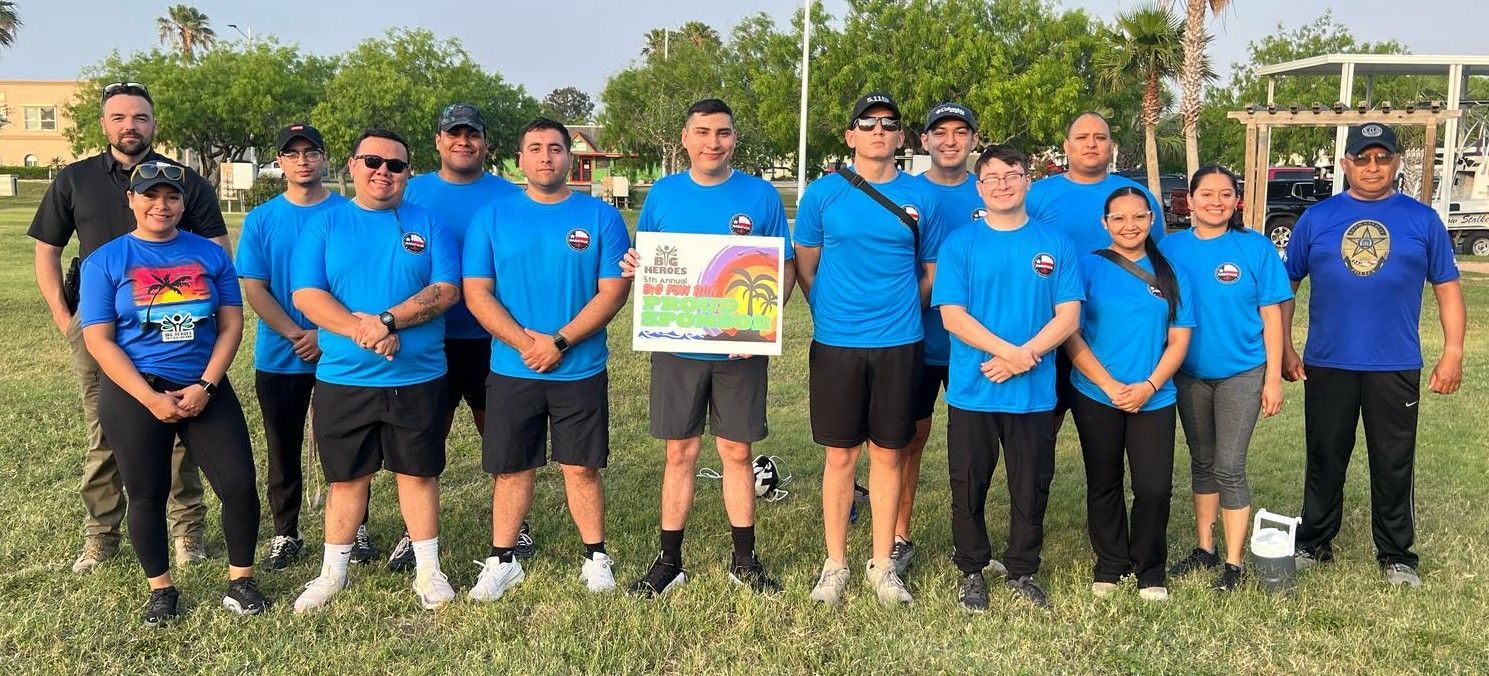 A group of people are posing for a picture in a field.