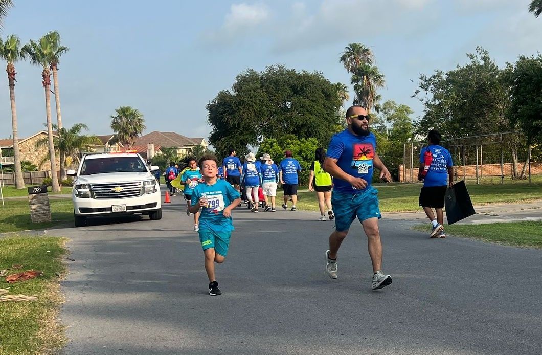 A group of people are running down a street.
