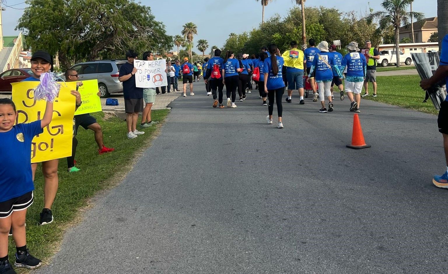 A group of people walking down a street holding signs