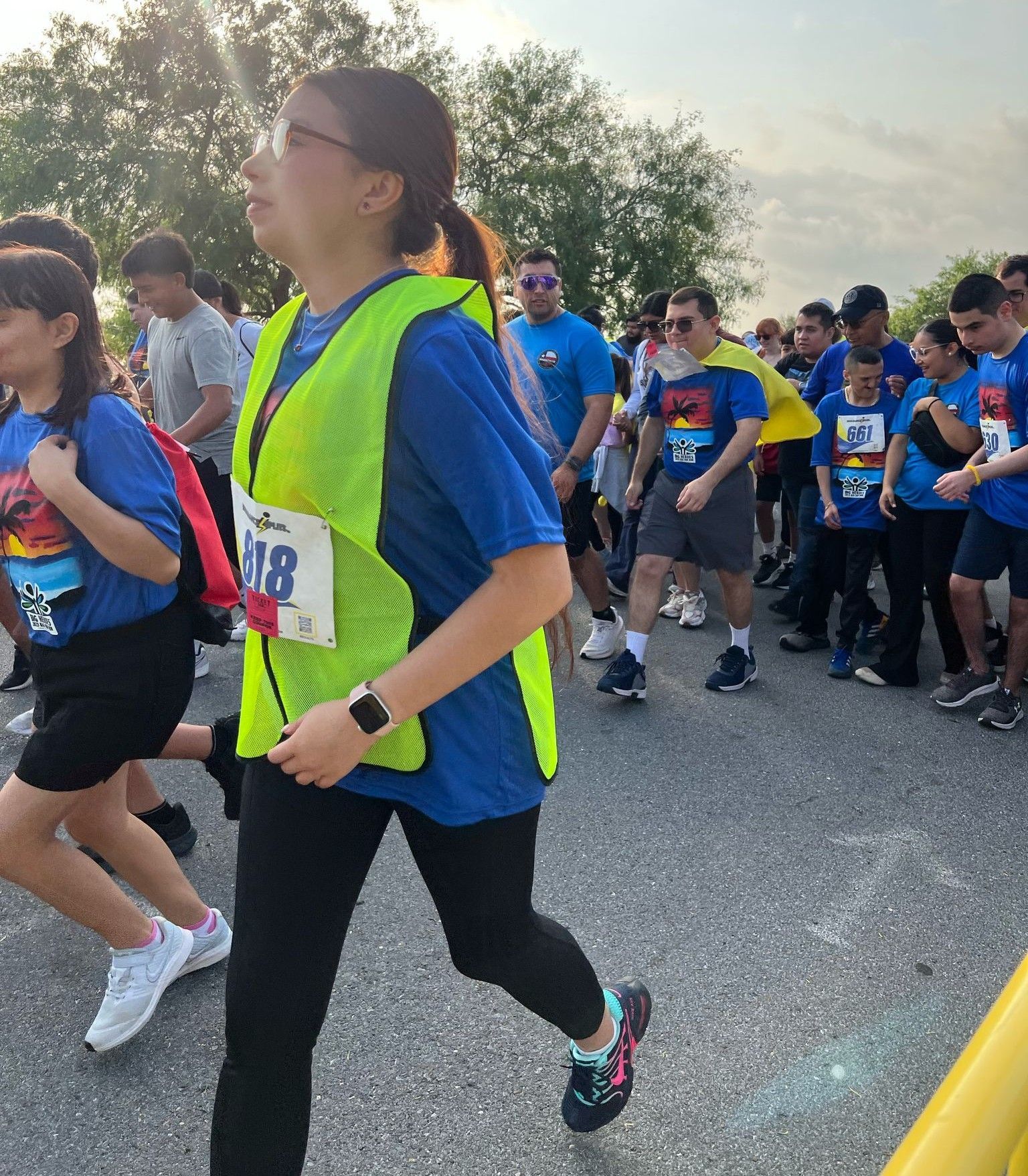 A woman wearing a yellow vest with the number 218 on it