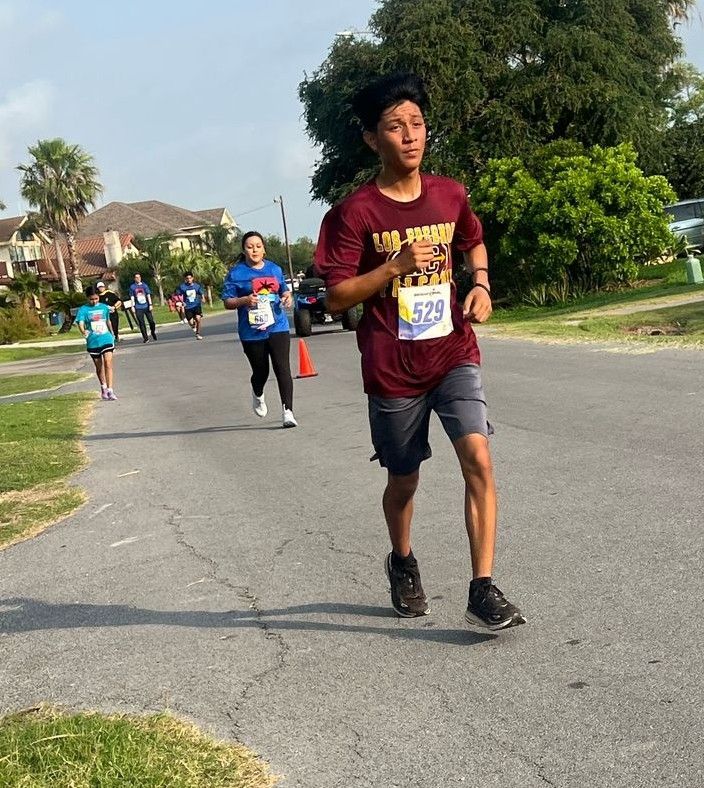 A man in a maroon shirt is running a race