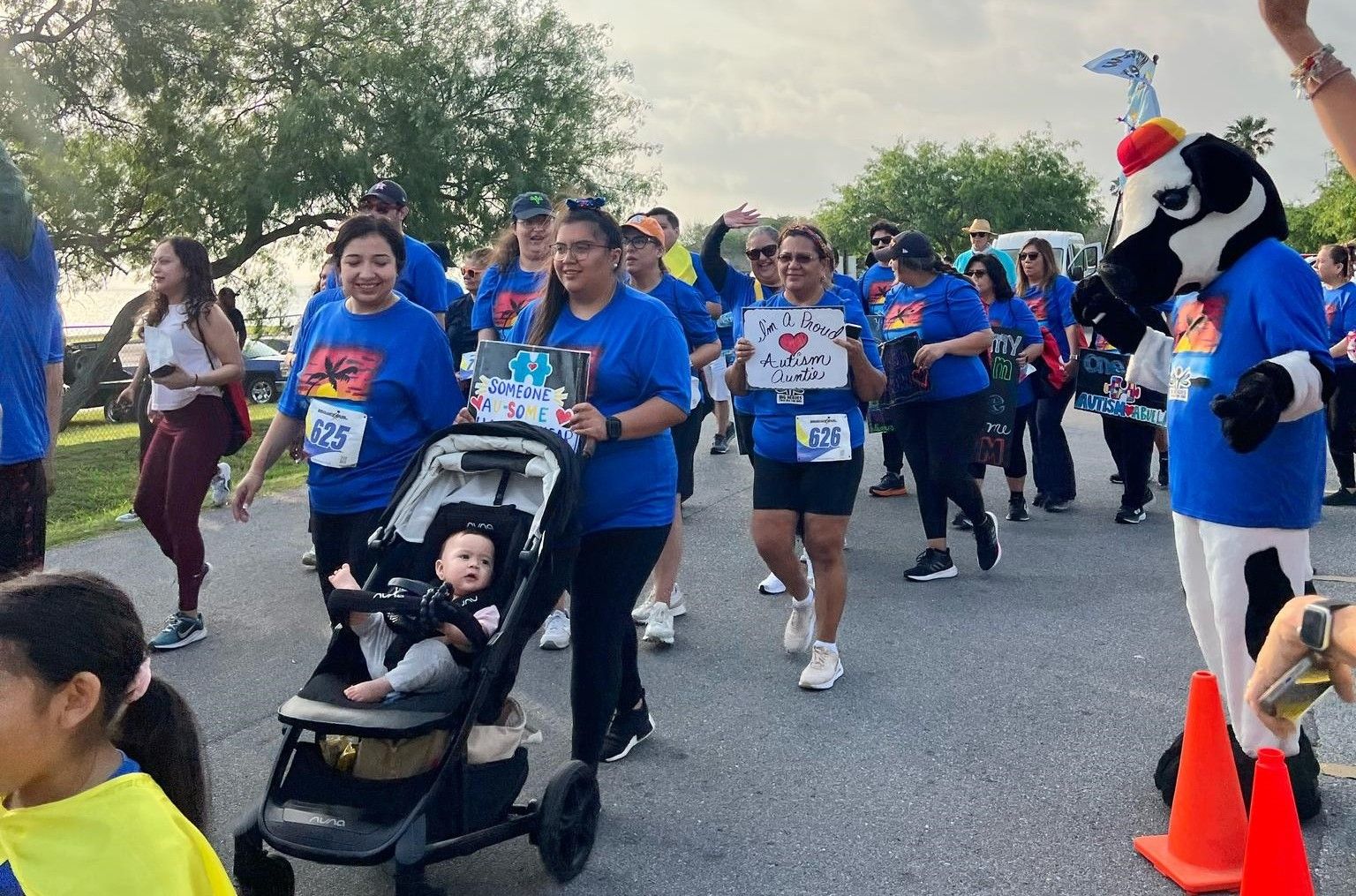A group of people are walking down a street with a baby in a stroller.