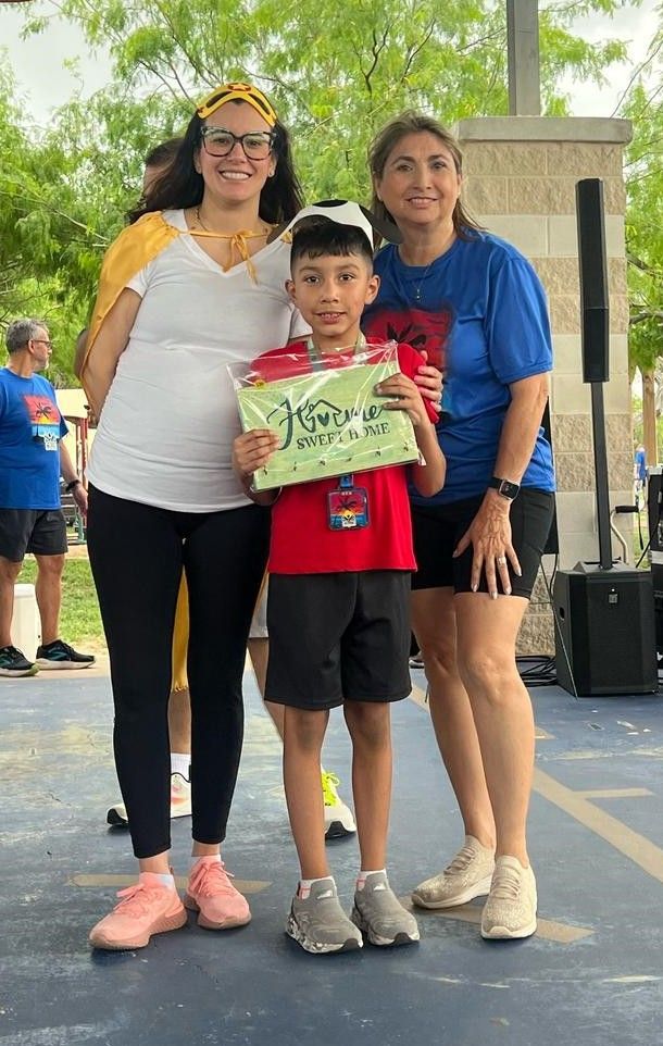 Two women and a boy are standing next to each other holding a certificate.