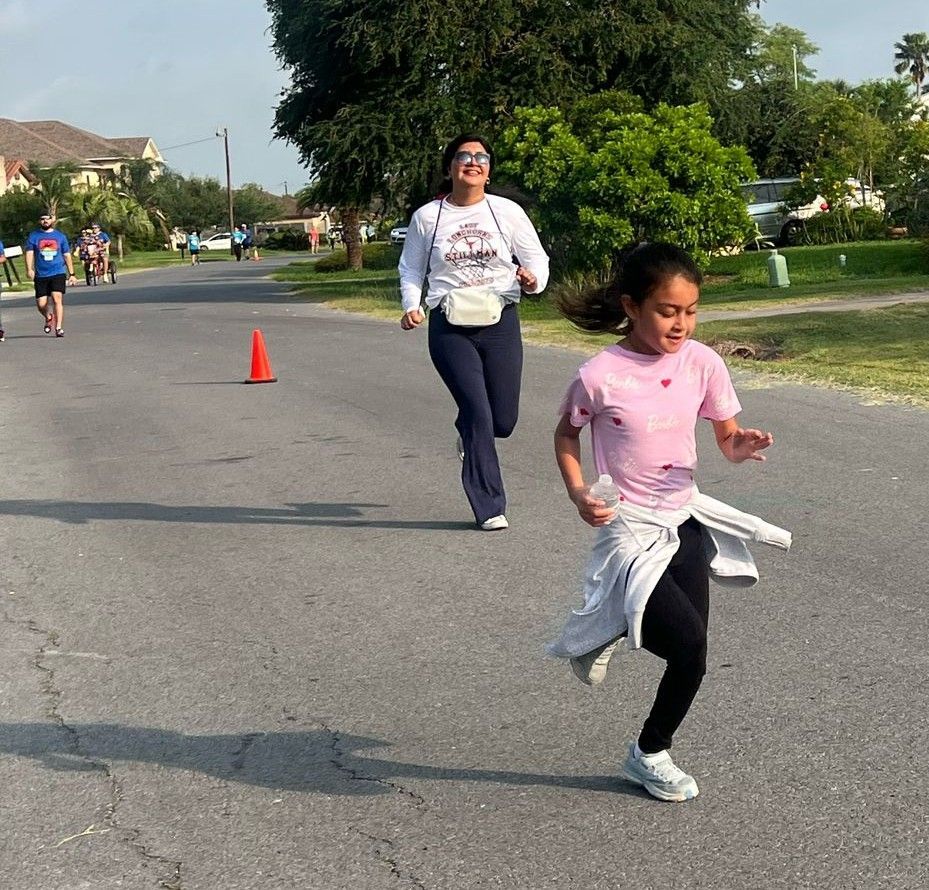 A woman and a girl are running down a street