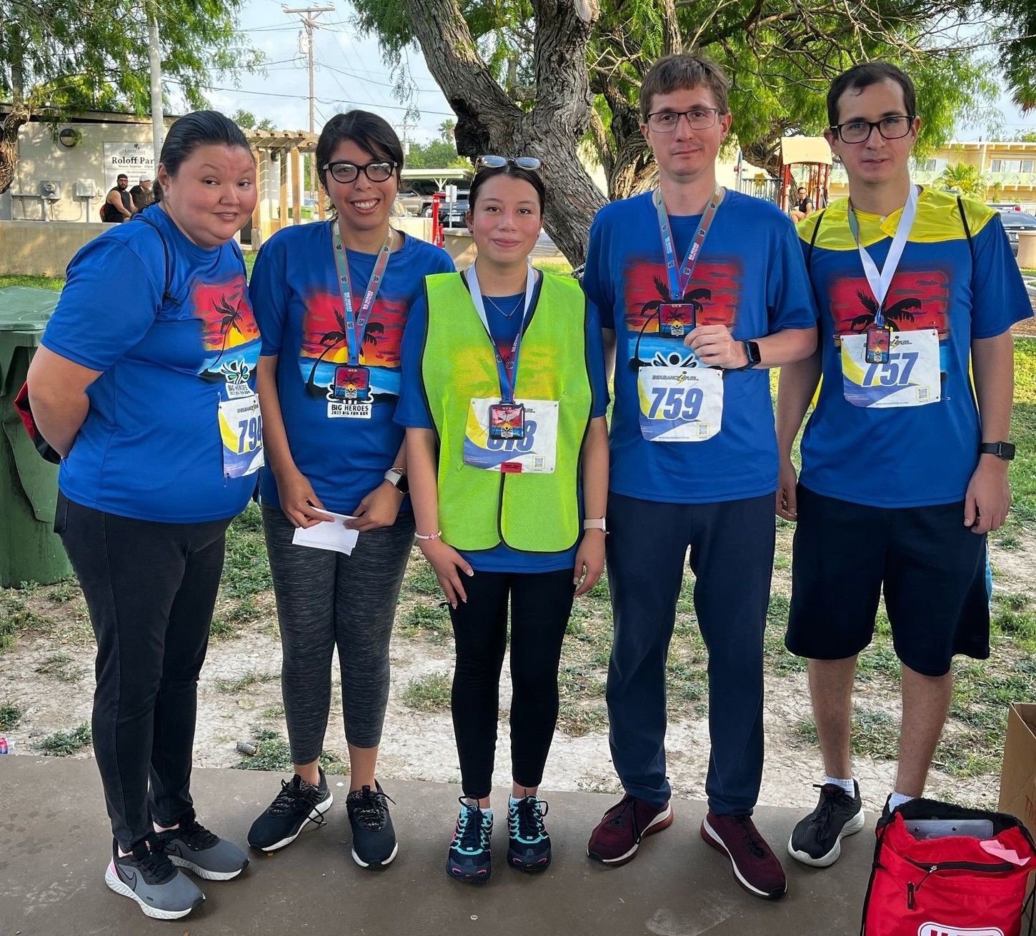 A group of people posing for a picture with one wearing a yellow vest with the number 759 on it