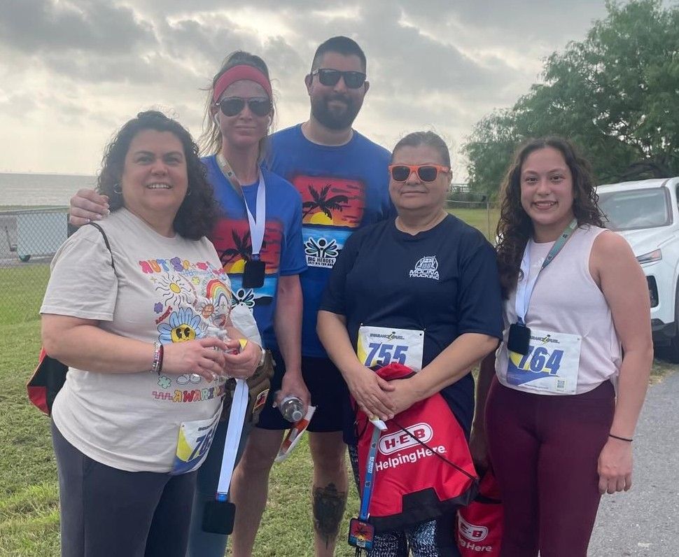 A group of people posing for a picture with one wearing a number 756 shirt.