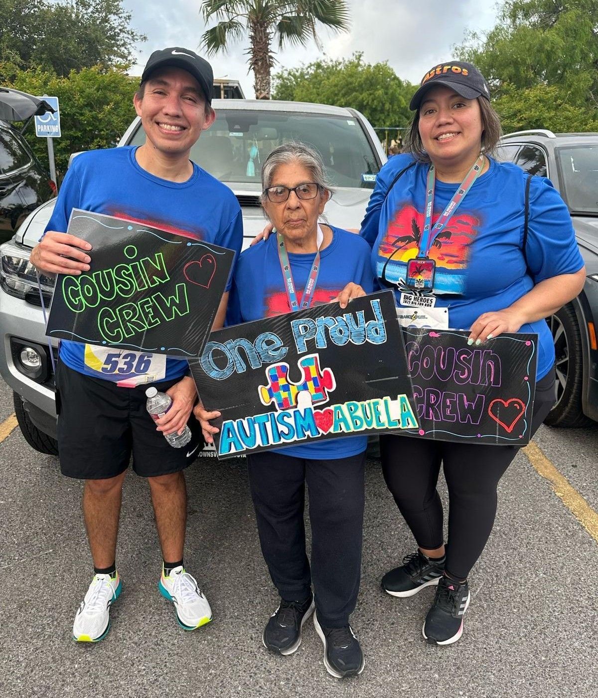 A group of people holding signs in front of a car.