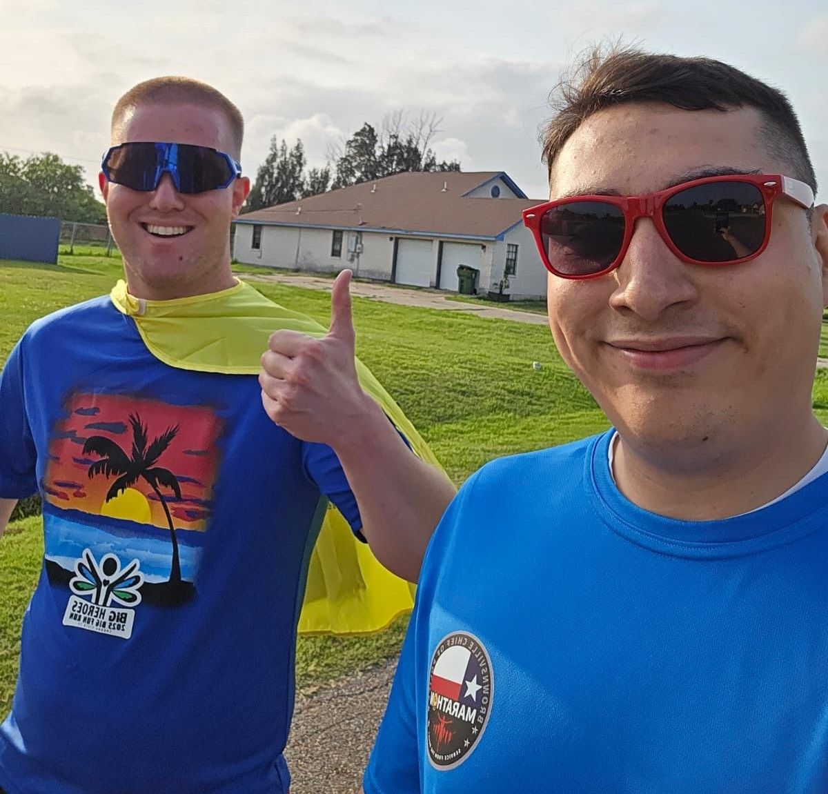 Two men are posing for a picture and one is wearing sunglasses