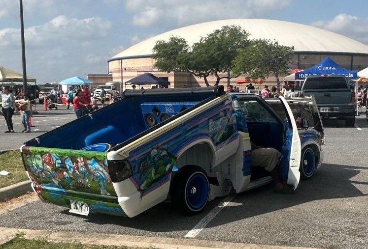 A blue and white truck is parked in a parking lot