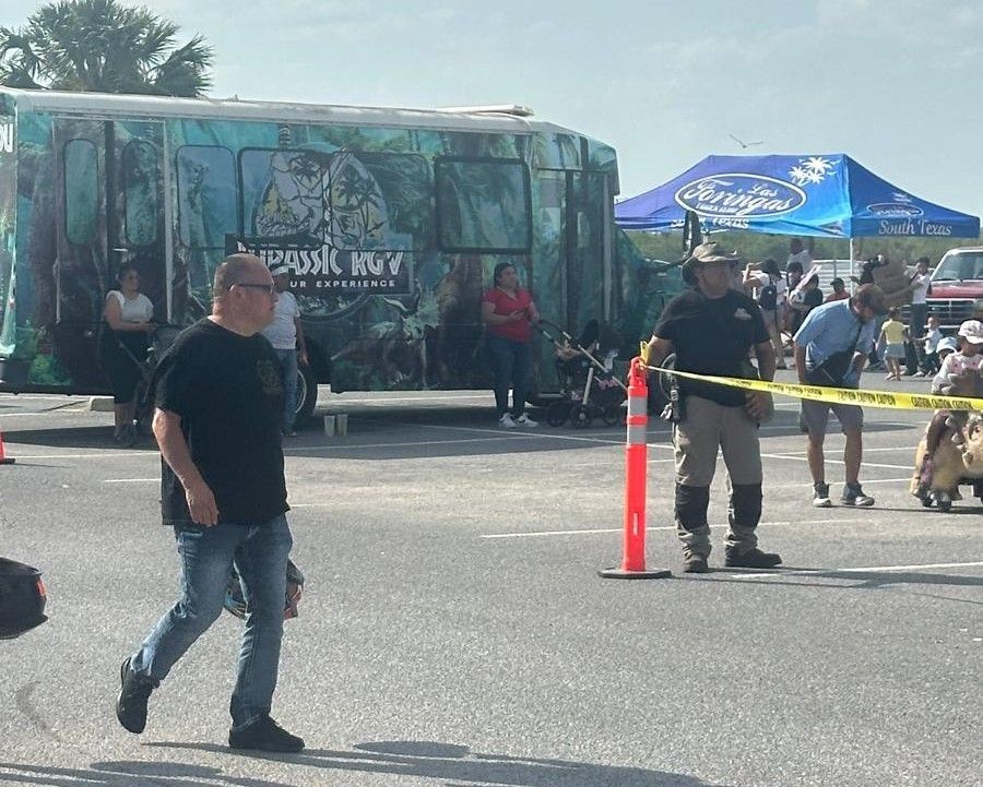 A man walking in front of a jurassic world bus