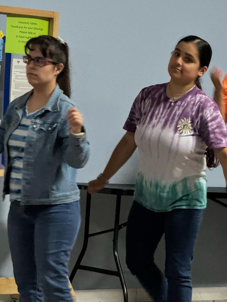A woman in a tie dye shirt is standing next to another woman