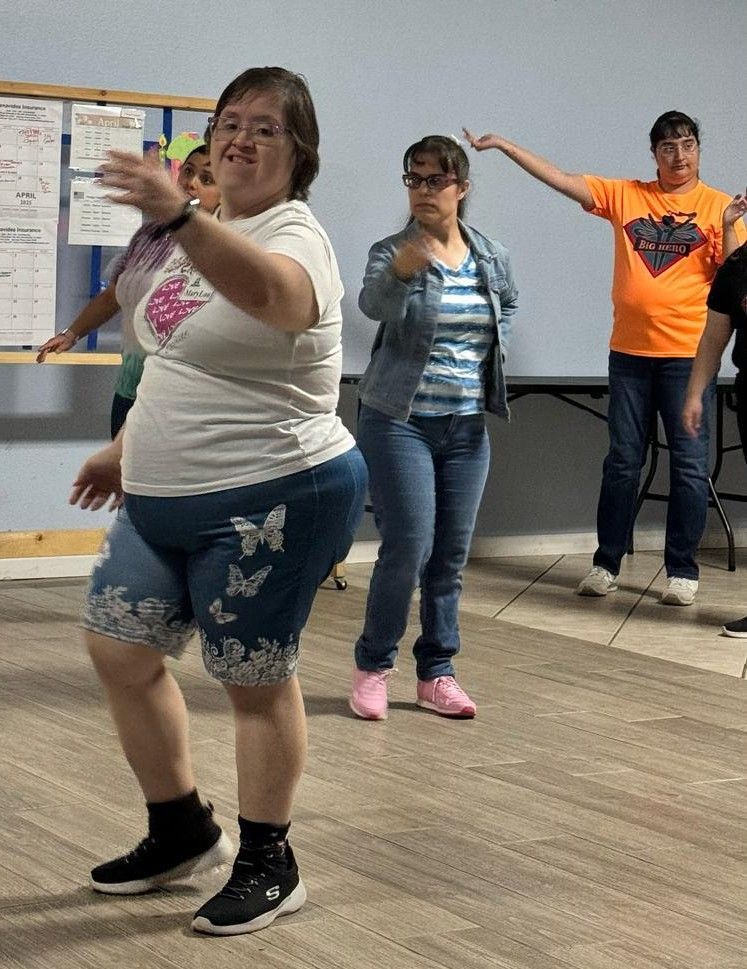 A group of people are dancing together in a room.