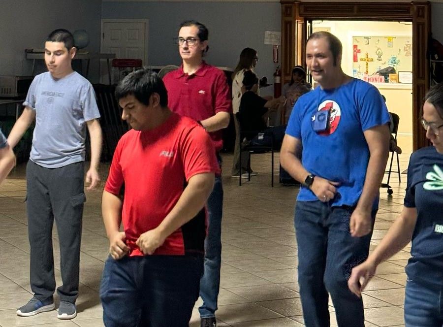 A group of people are standing in a room.