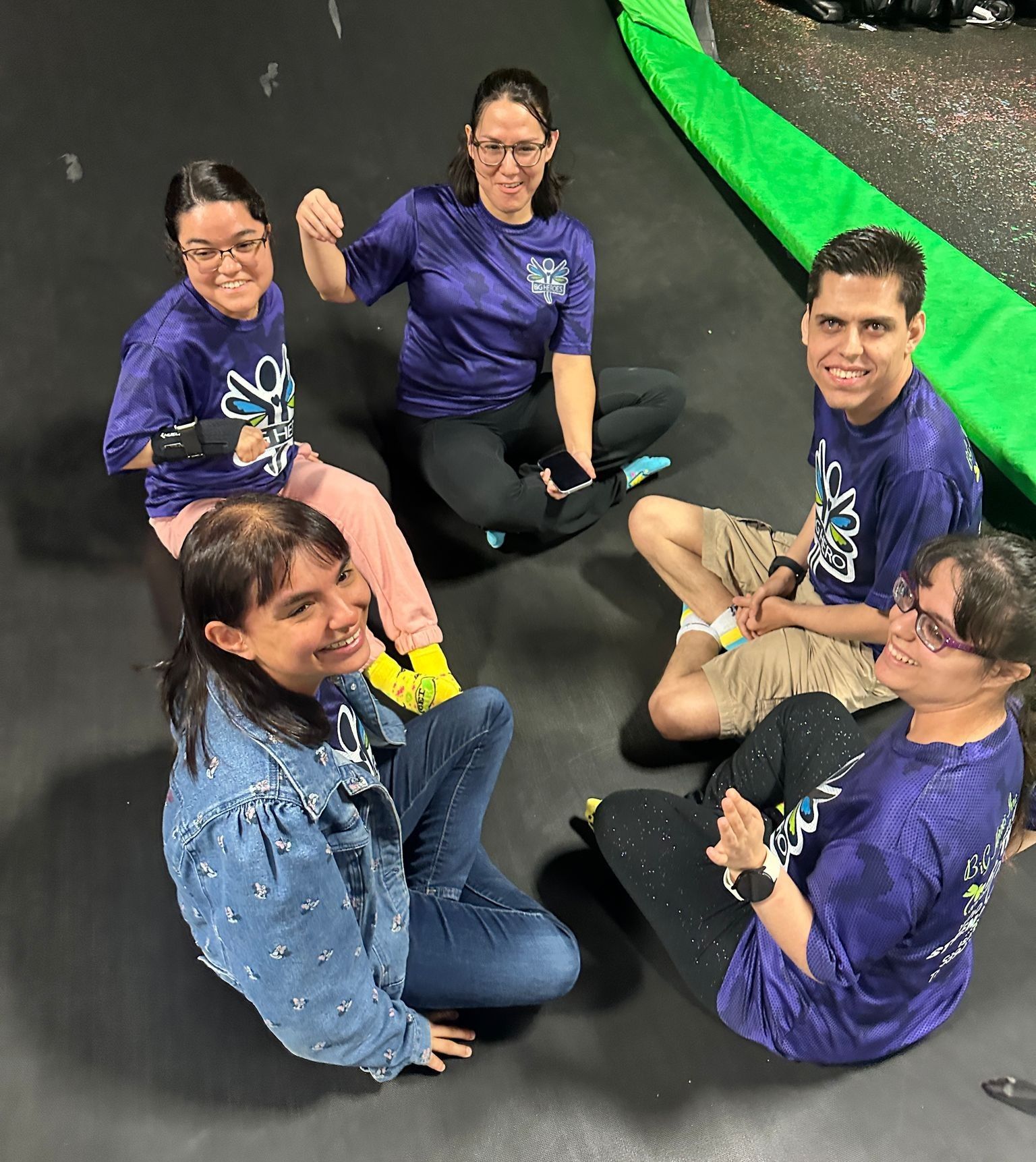 A group of people are sitting on the floor in a circle.