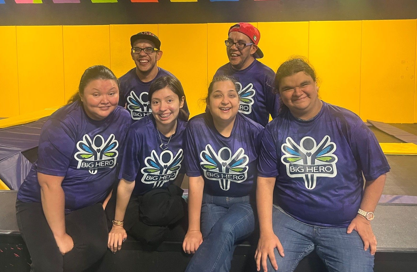 A group of people wearing purple shirts are posing for a picture.