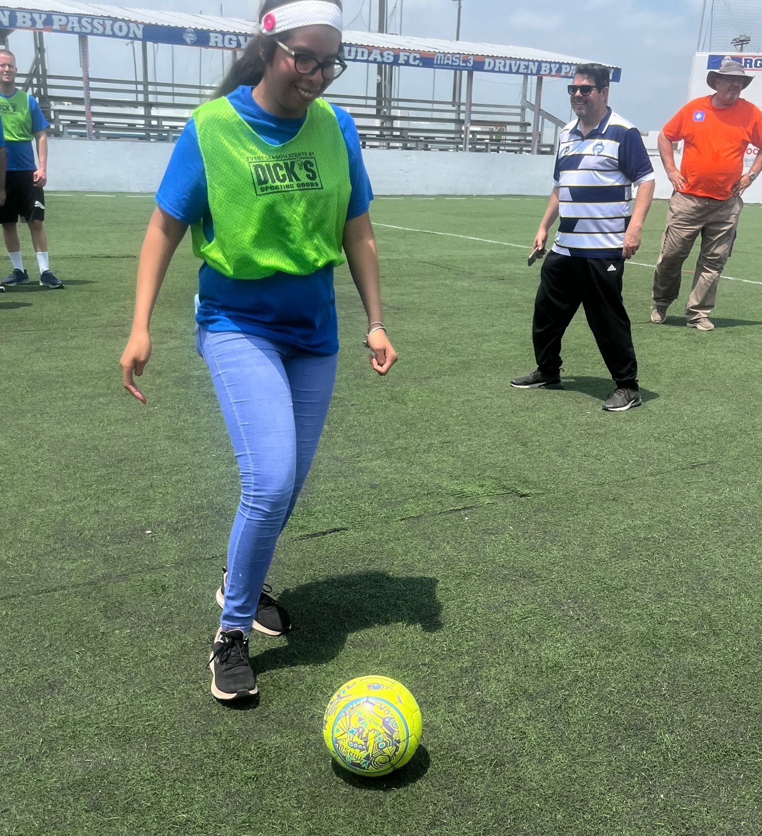 A woman kicks a soccer ball on a field