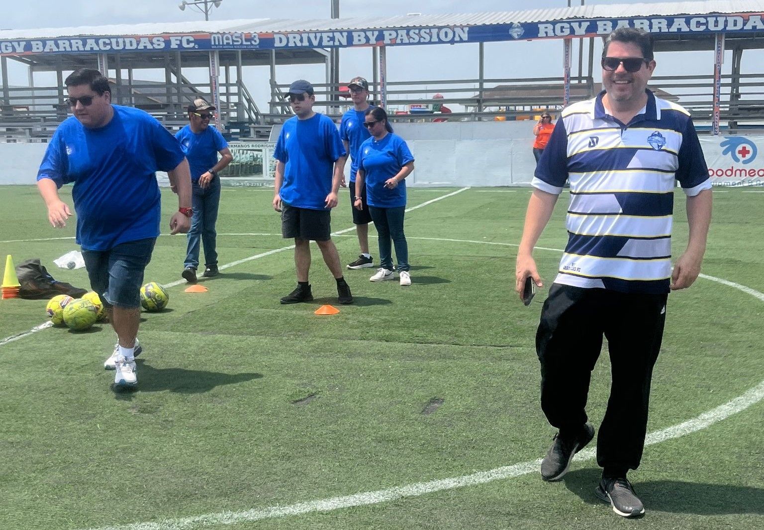 A group of people on a soccer field with a banner that says driven by passion
