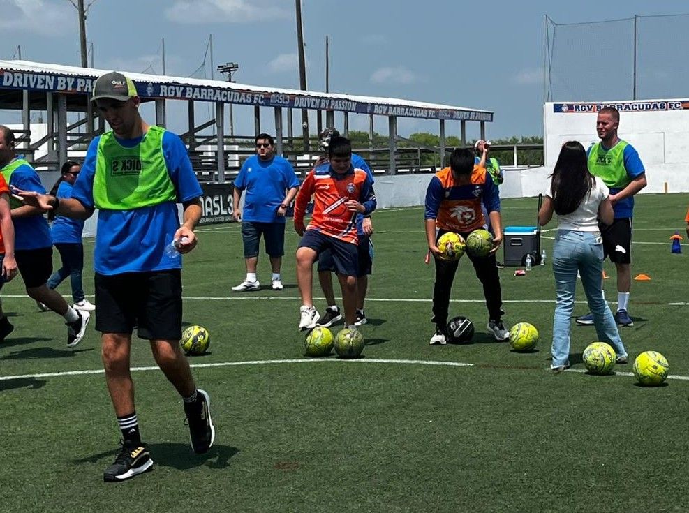 A group of people are playing soccer on a field