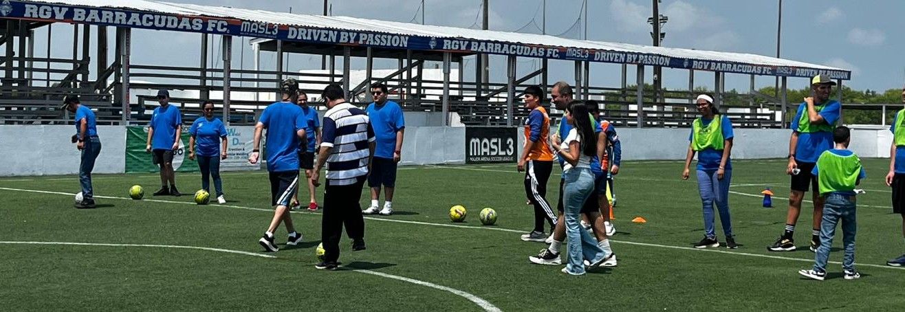 A group of people are playing soccer on a field.
