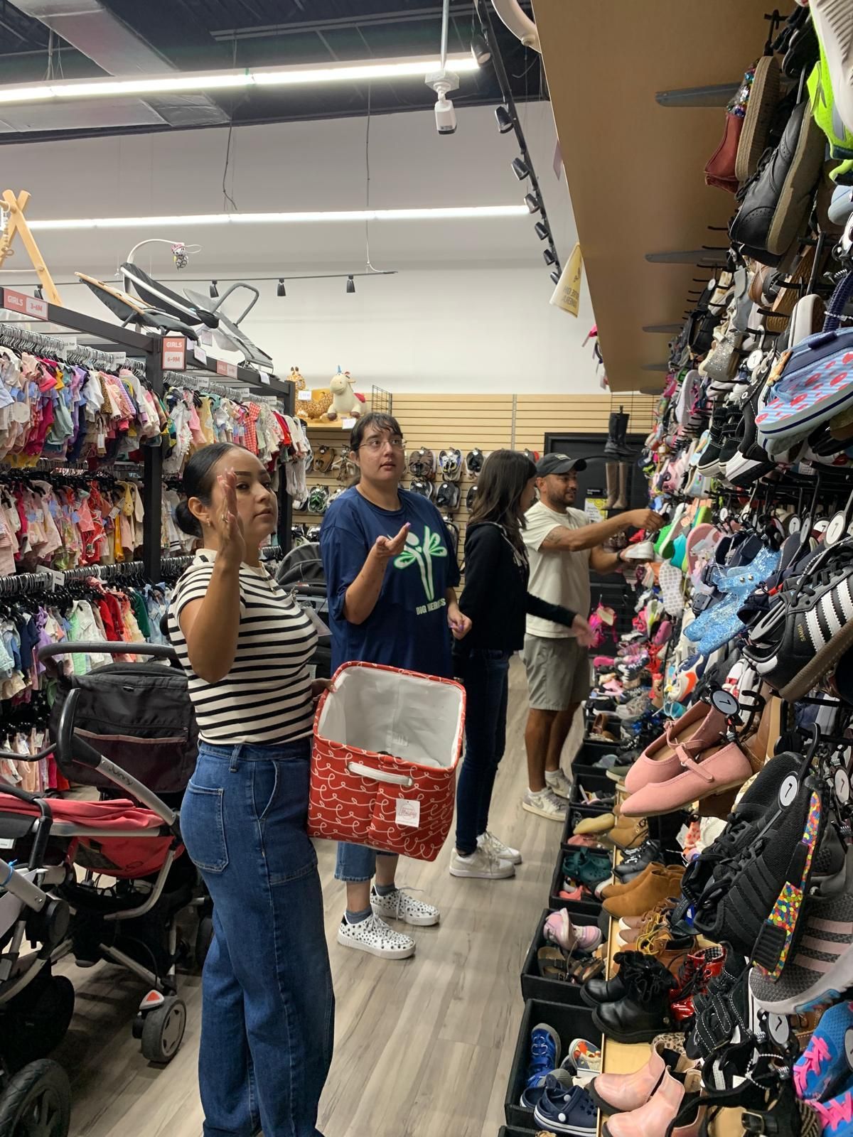People shopping in a store, browsing shoes and clothes.
