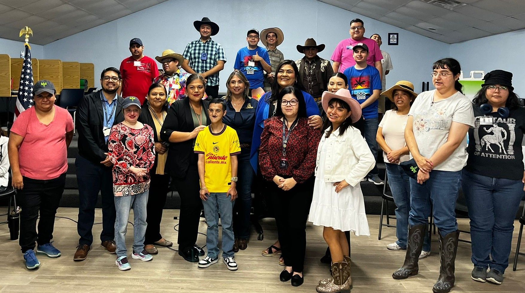 Group of people, many wearing cowboy hats, posing indoors.